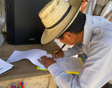 Hombre indígena firmando lista de asistencia