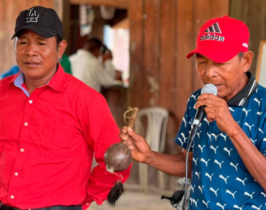Hombres indígenas hablando por micrófono