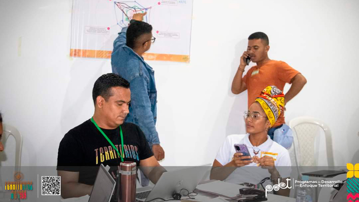 Tres hombres y una mujer participando en las mesas de trabajo